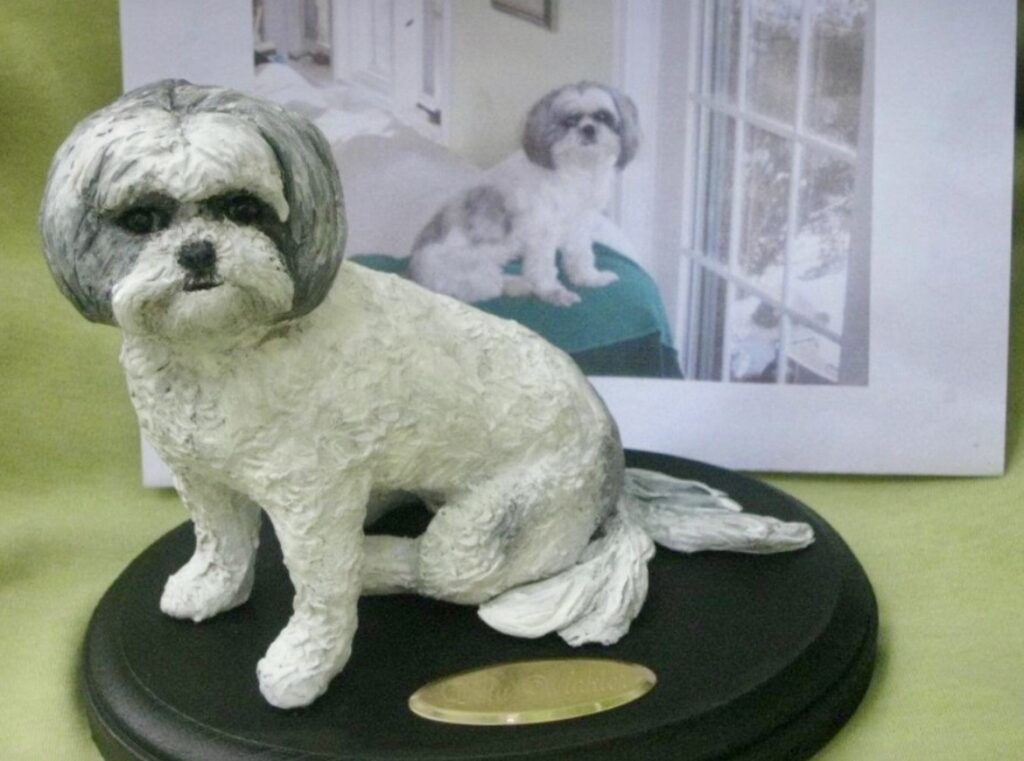 White furry dog on a black platform